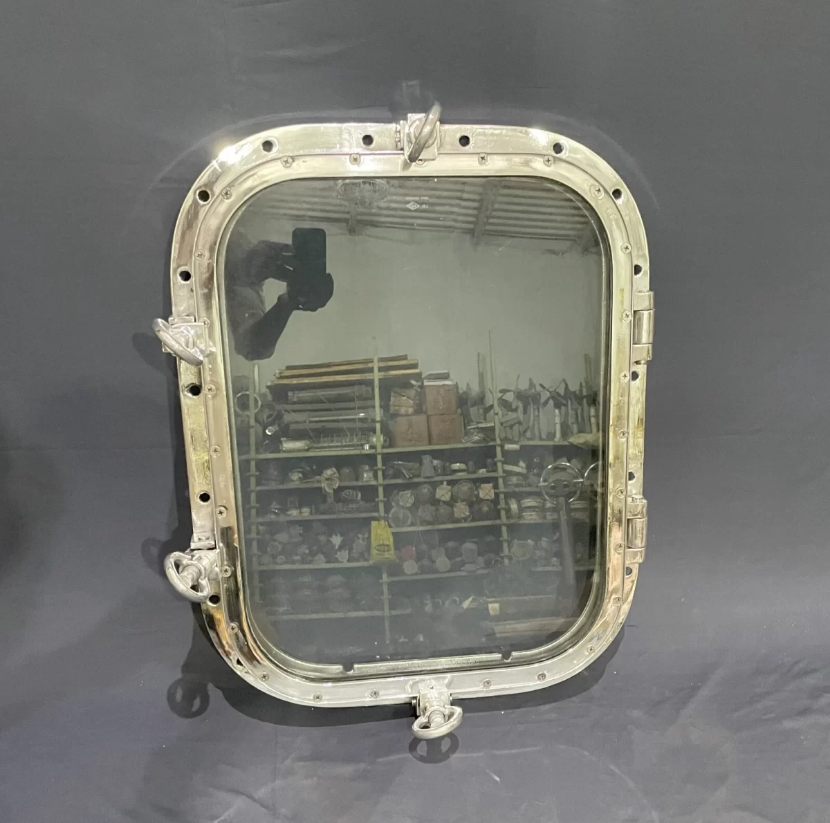 Authentic aluminum ship window with 18x24 inch glass, polished finish, hinges, and locking latches for nautical décor.