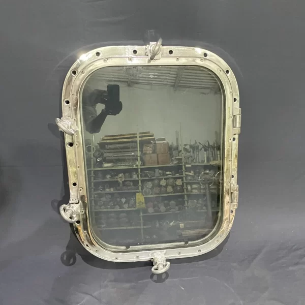 Authentic aluminum ship window with 18x24 inch glass, polished finish, hinges, and locking latches for nautical décor.